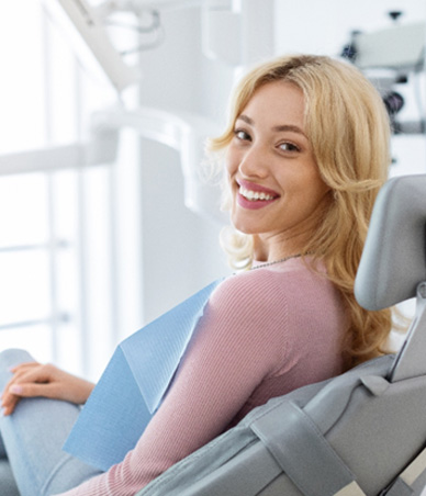 Smiling dental patient looking over her shoulder