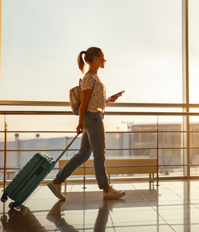 Woman rolling her suitcase through the airport