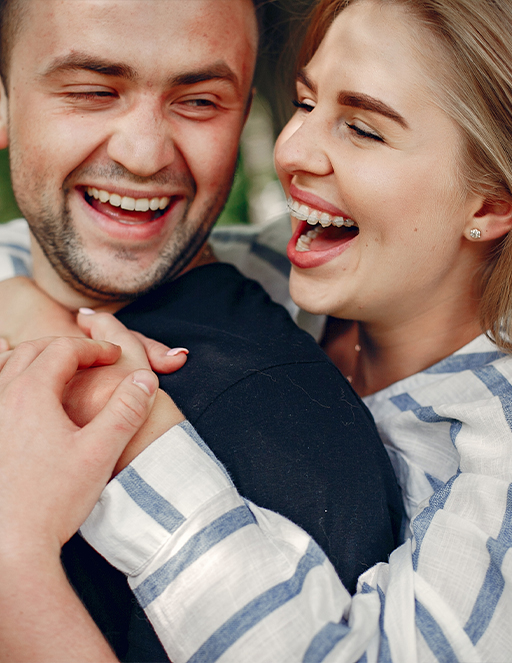 Man smiling with woman wearing braces from Houston orthodontic office