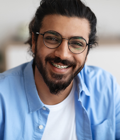 Young man with glasses and braces grinning