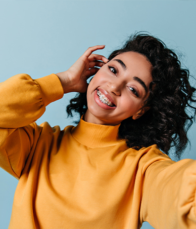 Smiling woman with braces and yellow sweater