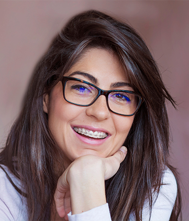 Woman with braces and long brown hair smiling