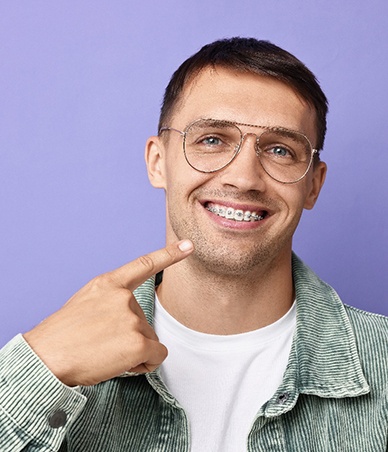 Smiling man pointing at his braces