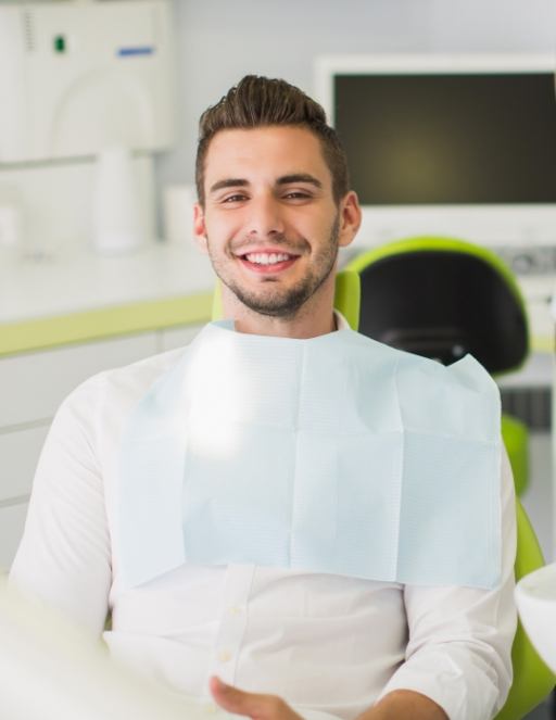 Smiling man sitting in treatment chair in Houston orthodontic office