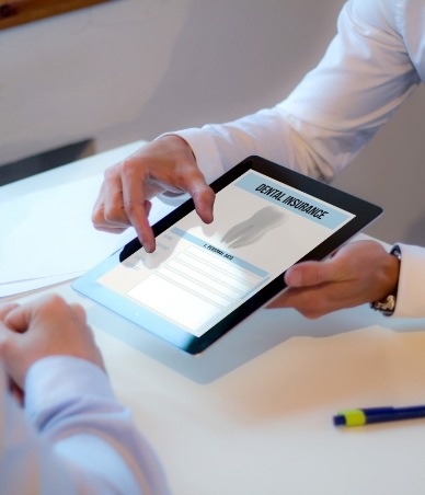 Two people looking at dental insurance forms on tablet