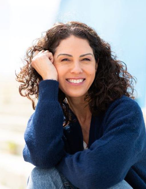 Happy, smiling woman sitting outside in the sun
