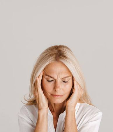 Woman holding her head, wearing pained expression
