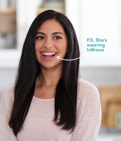 Smiling woman with arrow pointing to her smile and text that reads P S she is wearing InBrace