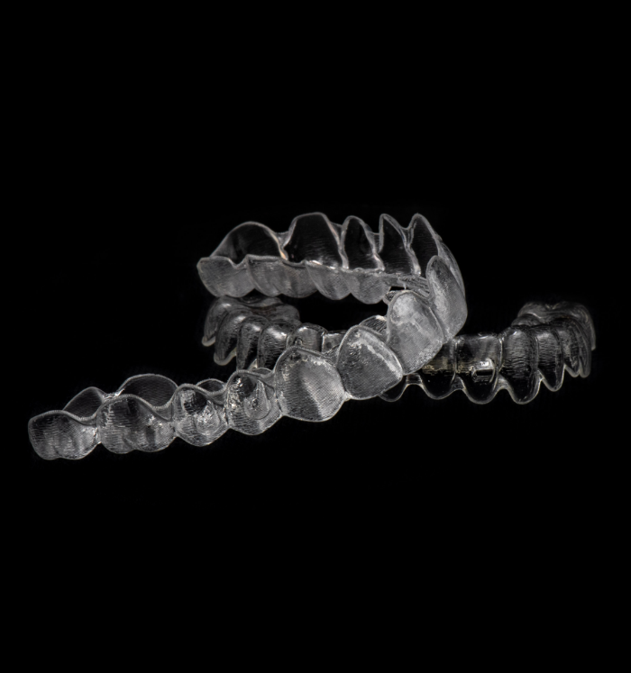 One clear aligner against black background
