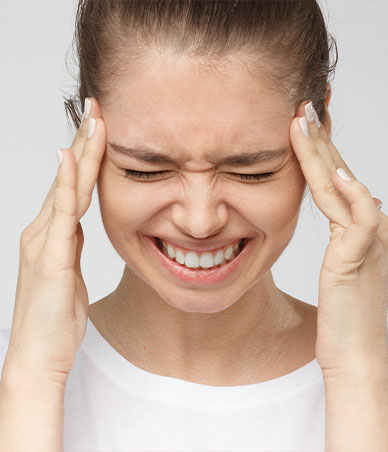 Close up of woman with eyes closed touching her temples