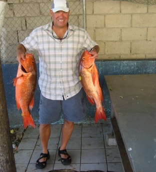 Doctor Hall holding two freshly caught pink fish