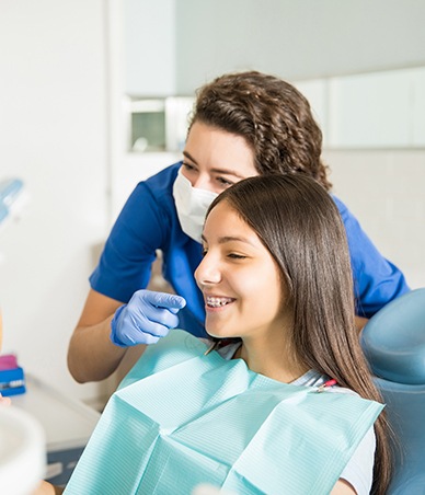Teen girl looking in the mirror to admire her braces