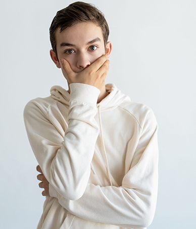 Teen boy covering his mouth