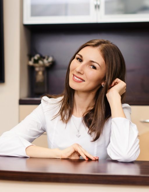 Smiling orthodontic team member sitting at desk