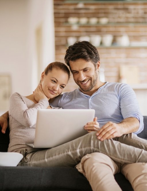 Man and woman looking at laptop for orthodontist reviews in Houston