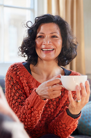 Smiling woman holding white coffee mug