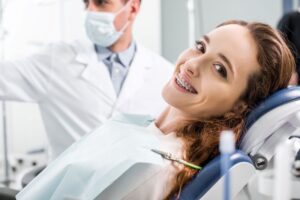 Smiling woman with braces in treatment chair